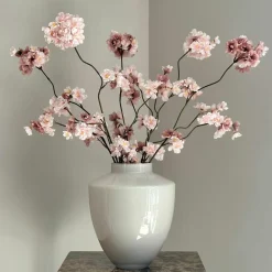 Beige vaas met roze zijden bloesemtakken