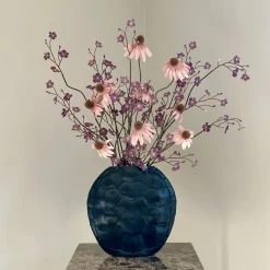 Zwarte ovale vaas met paars roze kunst bloemen